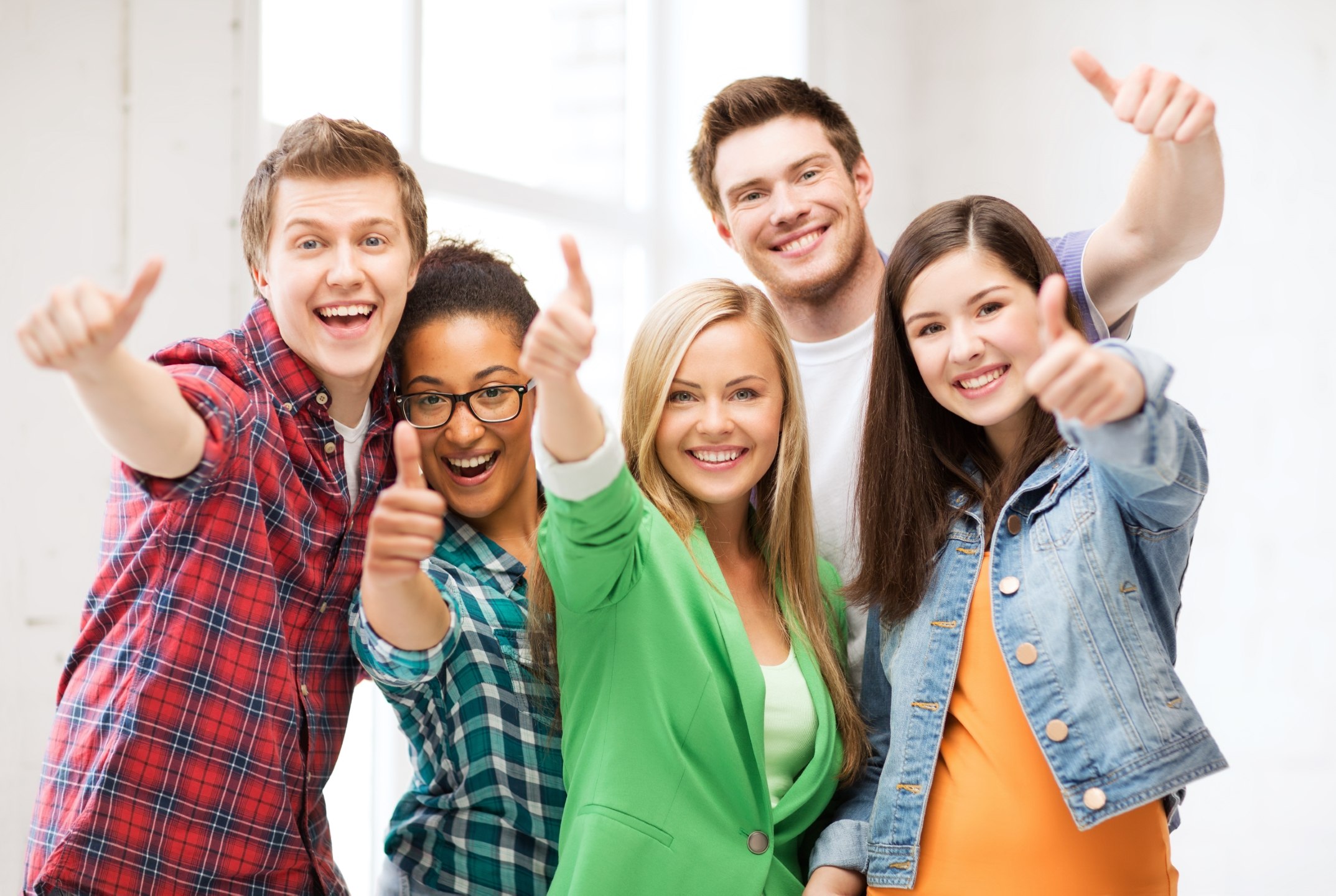 students showing thumbs up at school education concept - happy team of students showing thumbs up at school