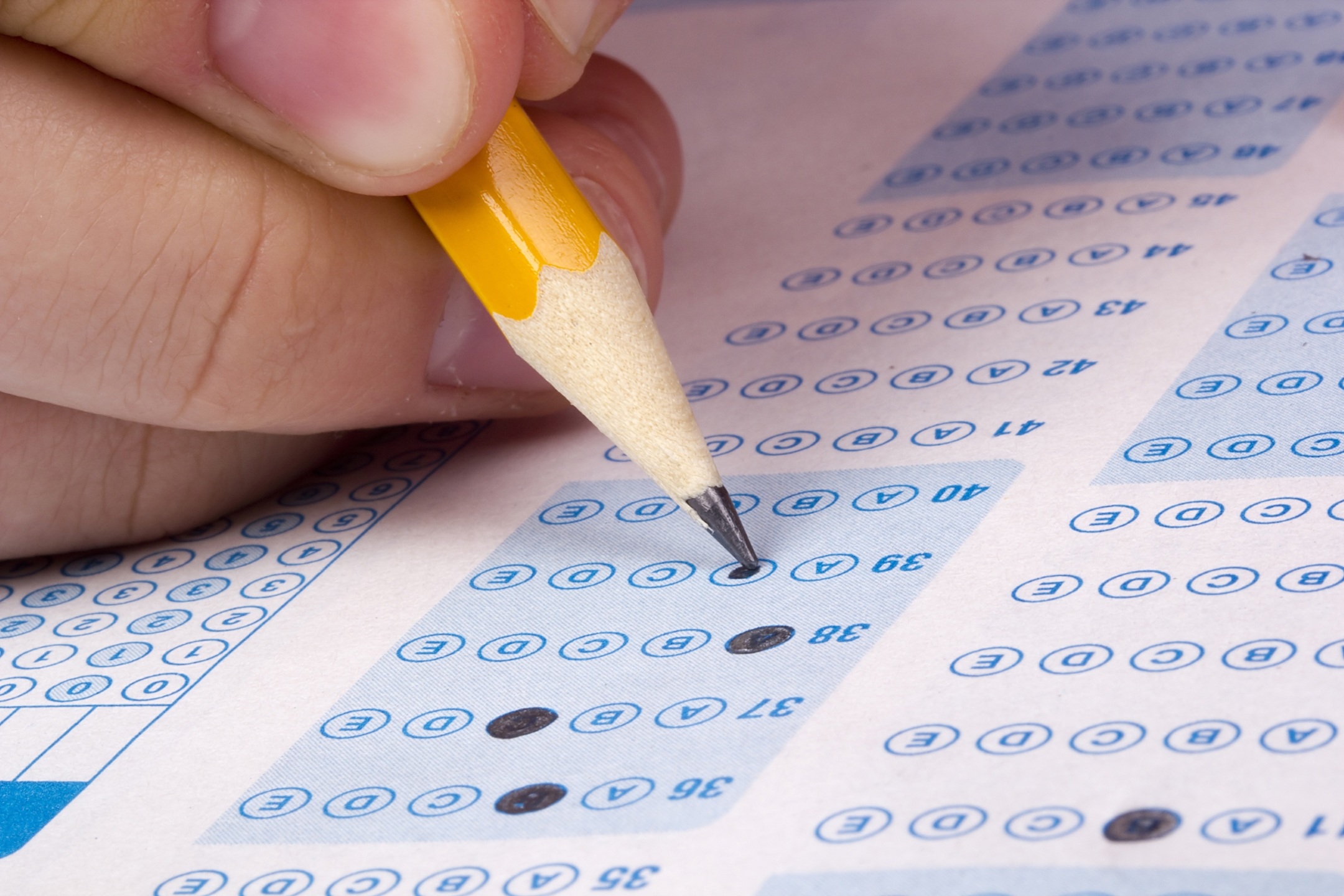 Taking a Test Student filling out answers to a test with a pencil.